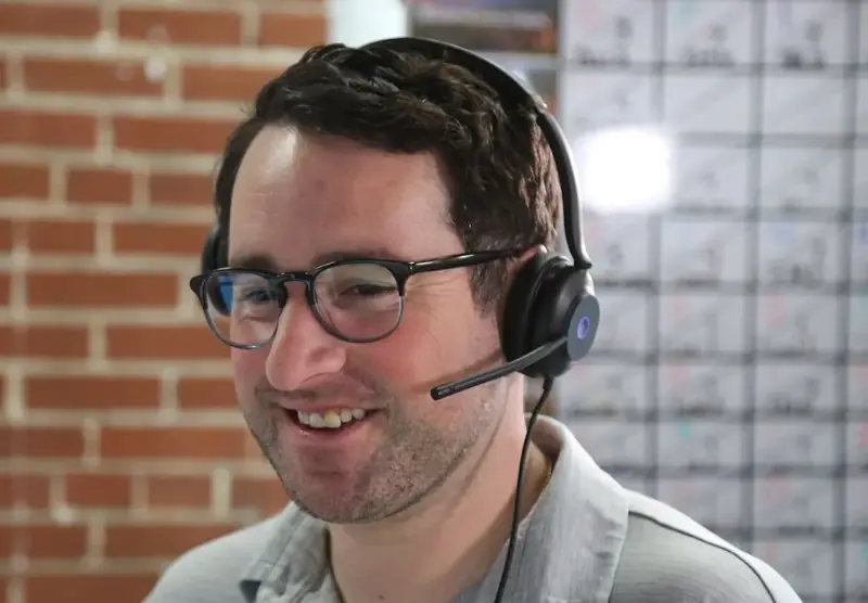 An Abstrakt sales development rep smiling on a headset call on the St. Louis sales floor