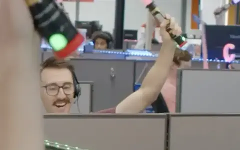 Abstrakt reps in headsets celebrating a booked meeting across the cubicles on the St. Louis sales floor