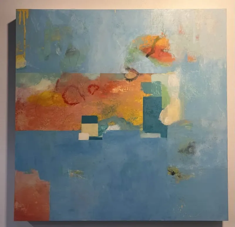 Abstract painting in layered blues with patches of orange and teal.