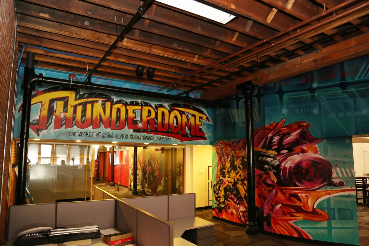 The Thunderdome, a sales room on the St. Louis campus with a comic-style sign and mural over the entrance