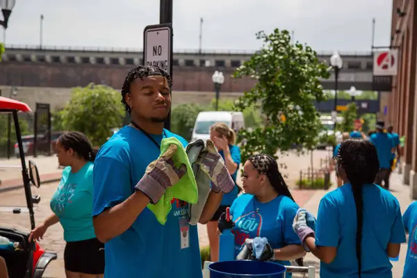 Volunteers in work gloves getting ready for a cleanup on a downtown street, 2022