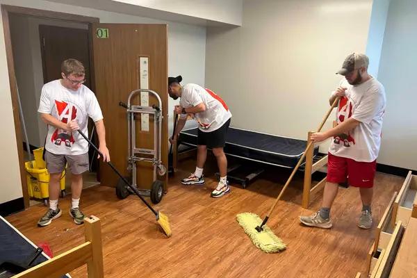 Volunteers sweeping and mopping a room at a partner nonprofit, 2023