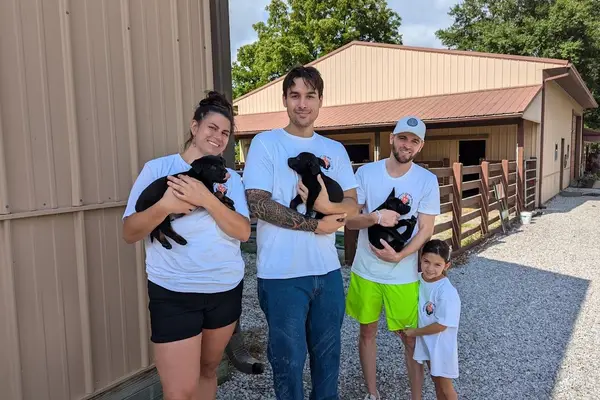 Volunteers holding puppies at an animal rescue, 2024