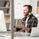 Man with a headset on talking in front of an imac