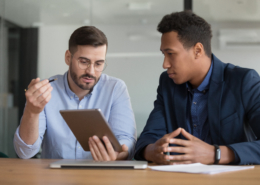 Diverse businessmen working on startup project using electronic tablet application