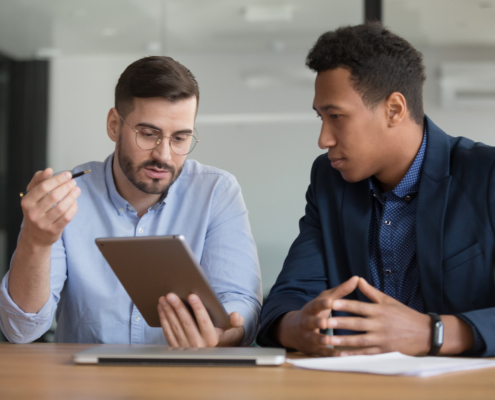 Diverse businessmen working on startup project using electronic tablet application