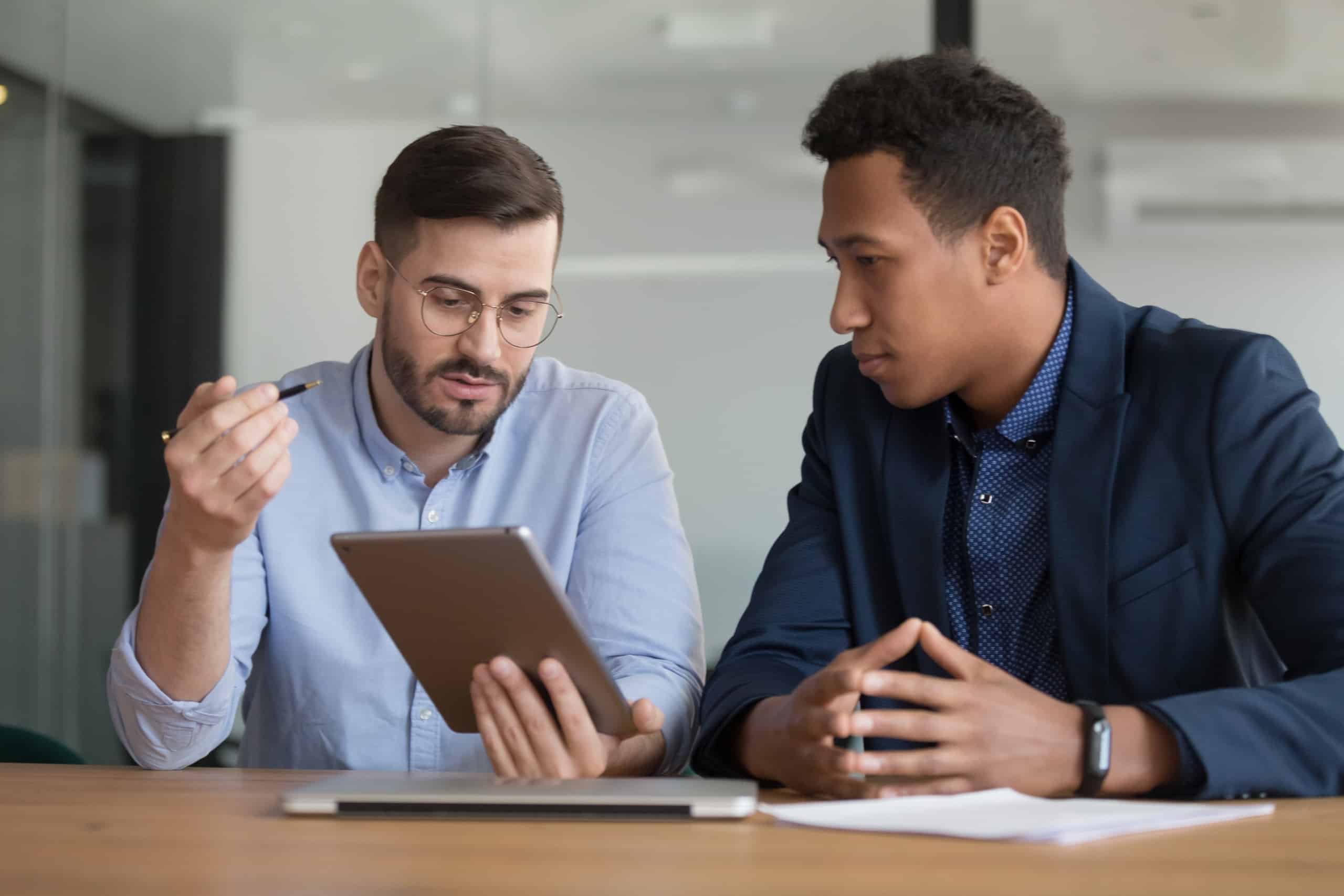 Diverse businessmen working on startup project using electronic tablet application