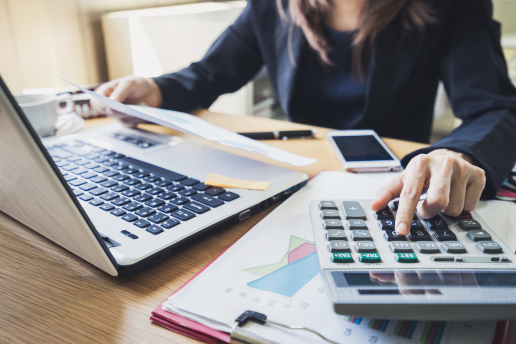 accountant working on a computer and using a calculator