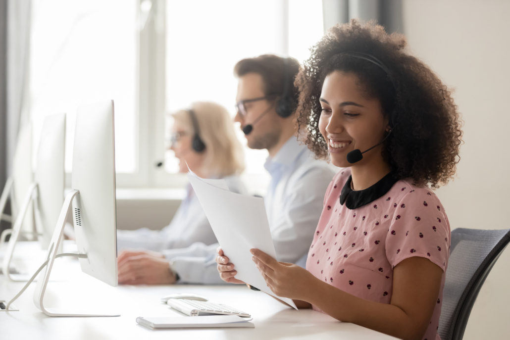 Lead qualification sales representative Smiling woman call center operator wearing headset reading papers