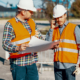 two paving construction workers talking about project plans