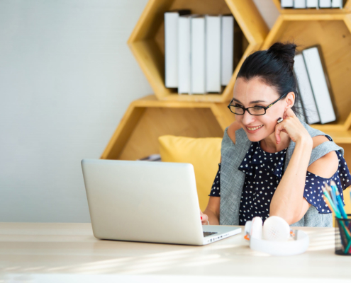 Happy-excited-successful-Beautiful-businesswoman-triumphing-in-modern-office-with-laptop,-success-happy-pose.-Work-from-home-and-social-distancing