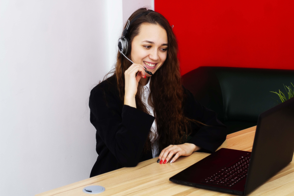 Outsourcing vs. Internalizing Your Cold Calling sales representative looking at laptop with a headset on