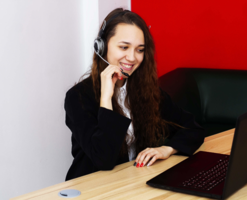 sales representative looking at laptop with a headset on