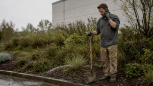Commercial landscaping account manager walking a property with a property manager, inspecting a low area that holds water
