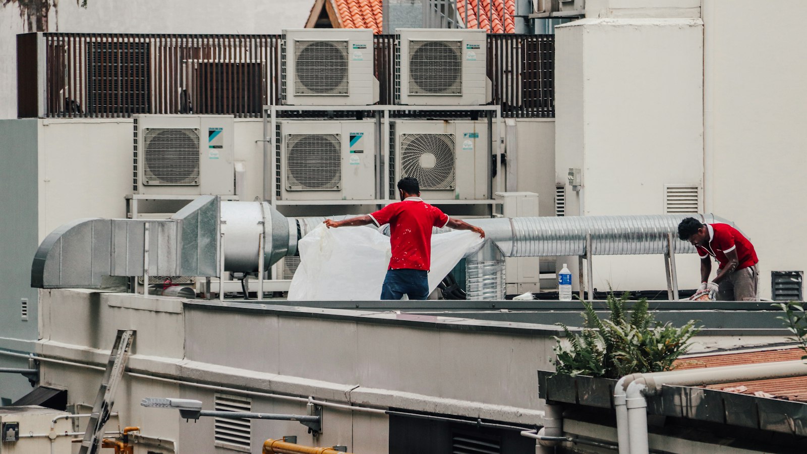 Technicians working beside rooftop HVAC units